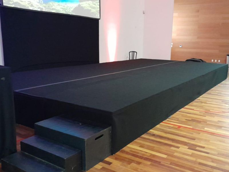 Palco montado para show ou evento corporativo com estrutura metálica e iluminação cênica, fotografia noturna profissional