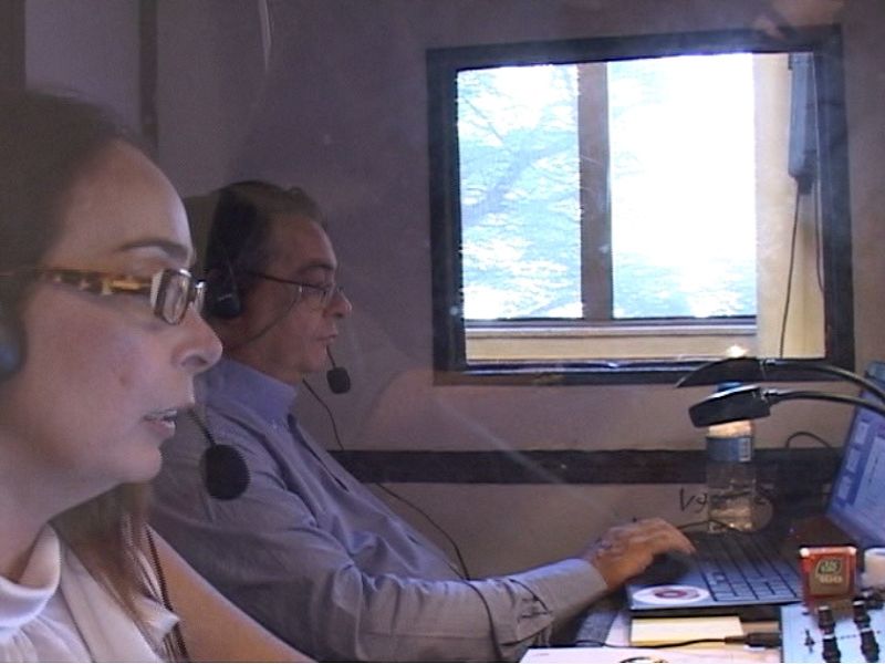 Cabines de tradução simultânea com fones de ouvido e equipamentos técnicos em congresso corporativo, fotografia profissional