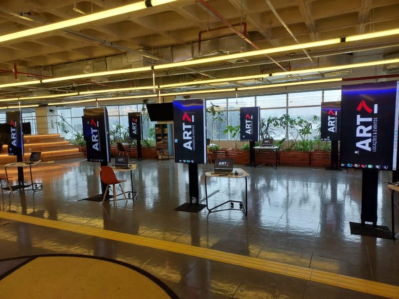 Televisores de alta definição instalados em estande de evento corporativo, fotografia profissional com iluminação controlada